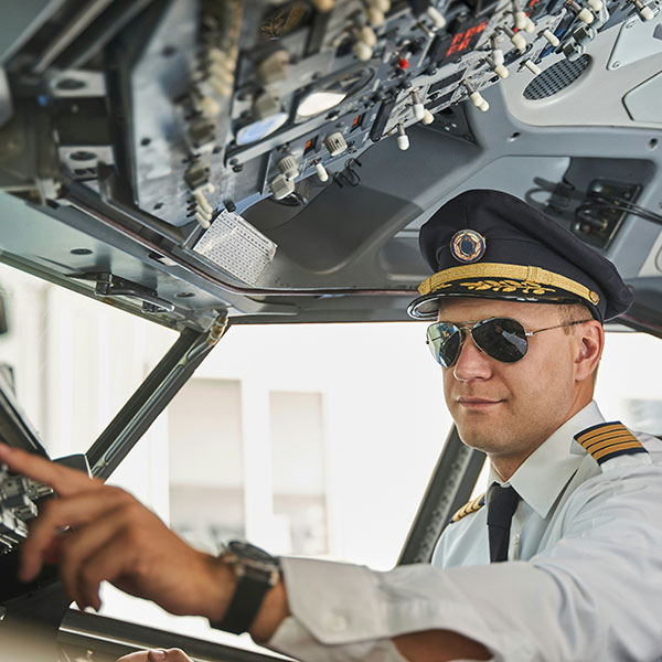 Pilot in cockpit, checking gauges